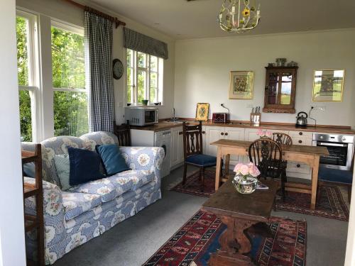 a living room with a couch and a kitchen at Te Kopura Lodge in Martinborough