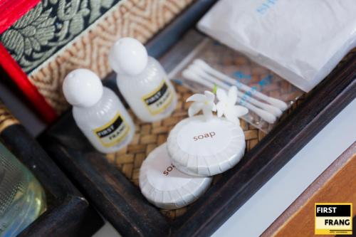 a box with three bottles of sauce and white plates at First and Frang Hotel - Koh Phangan in Thongsala