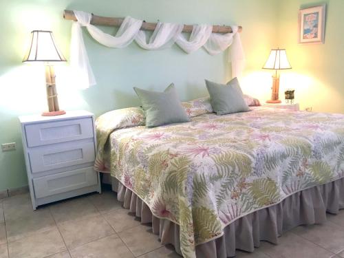 a bedroom with a bed with a dresser and lamps at Tranquility by the Sea in Vieques