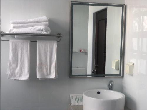 a bathroom with a sink and a mirror and towels at CONTENTO RETREAT in Hulhumale