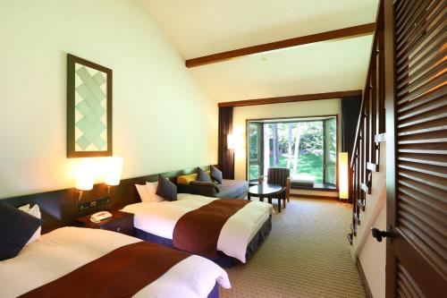 a hotel room with two beds and a window at Tateshina Tokyu Hotel in Chino