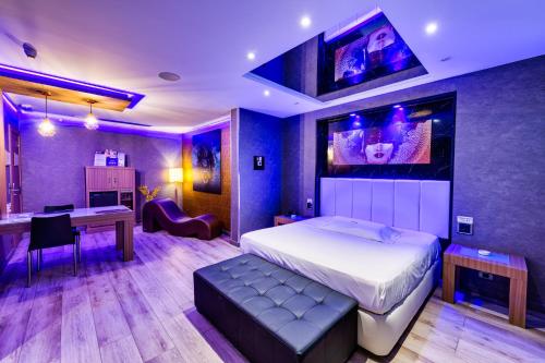 1 dormitorio con 1 cama grande, escritorio y mesa en Zouk Hotel, en Alcalá de Henares