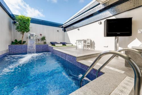 a swimming pool with a tv and a swimming pool at Zouk Hotel in Alcalá de Henares