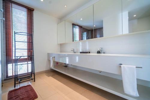 a bathroom with a large white sink and a mirror at Pranaluxe 4 Bedroom Pool Villa F1 in Pran Buri