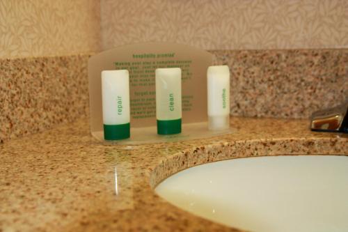a bathroom sink with three candles on a counter at Holiday Inn Express Hotel & Suites Manchester - Airport, an IHG Hotel in Manchester