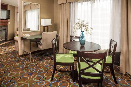 a hotel room with a table and a desk at Holiday Inn Express Hotel & Suites Manchester - Airport by IHG in Manchester