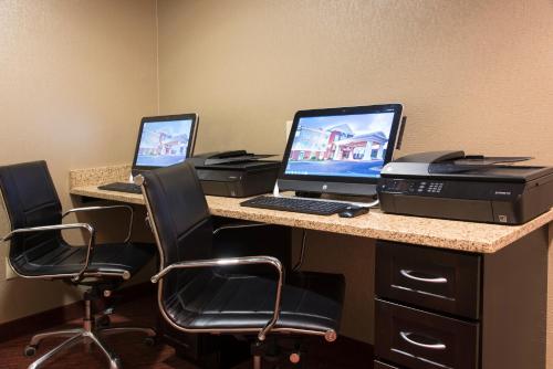 a desk with two computers and a printer on it at Holiday Inn Express Hotel & Suites Grand Rapids-North by IHG in Grand Rapids
