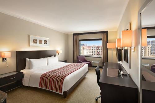 a hotel room with a bed and a desk at Ramada Plaza by Wyndham Dubai Deira in Dubai