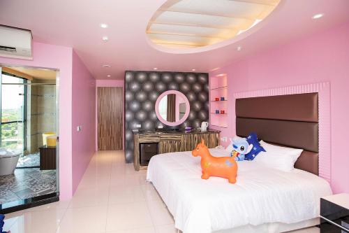 a pink bedroom with a bed with a horse toy on it at Diudiu Dang Paternity B&B in Dongshan