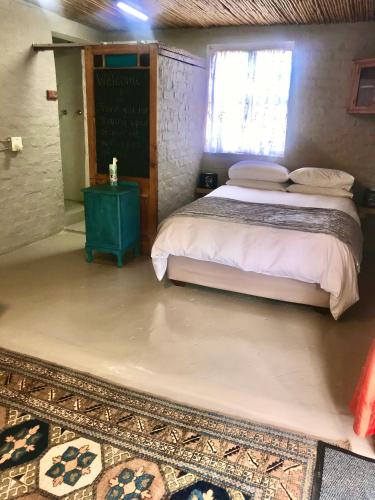 a bedroom with a bed and a chalkboard on the wall at A Piece of Life in Bredasdorp