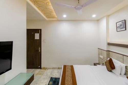 a bedroom with a bed and a tv and a door at Hotel City Inn in Ahmedabad