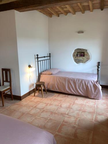 a bedroom with two beds and a table and a chair at Casa vacanza vicolo degli orti in Monticiano
