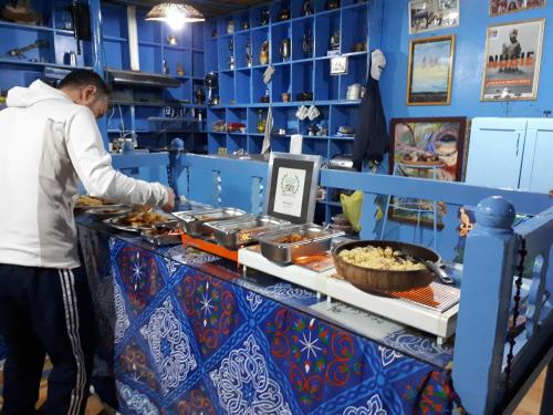 a man preparing food at a buffet in a restaurant at Bet El Kerem Guesthouse in Aswan