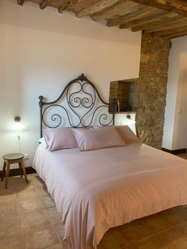 a bedroom with a large bed with a stone wall at Casa vacanza vicolo degli orti in Monticiano