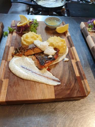 ein Holzschnitttafel mit Essen auf dem Tisch in der Unterkunft Bed and Breakfast Turist in Staro Petrovo Selo