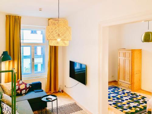 uma sala de estar com um sofá e uma televisão em Contemporary City Apartment - by Nahuen Suites em Graz