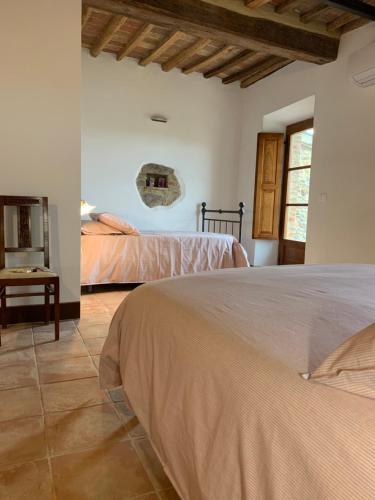 a bedroom with two beds and a table at Casa vacanza vicolo degli orti in Monticiano