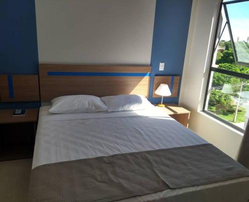une chambre avec un grand lit et une fenêtre dans l'établissement Alta vista termas resort, à Caldas Novas