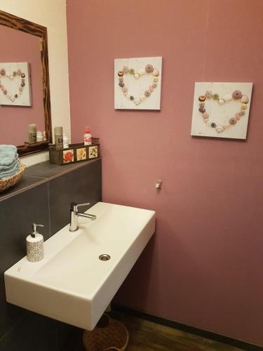 a bathroom with a sink and two hearts on the wall at FeWo Time Out 2 in Vreden