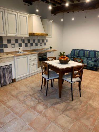 a kitchen with a table with a bowl of fruit on it at Casa vacanza vicolo degli orti in Monticiano