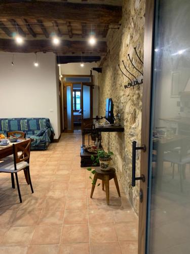 a living room with a stone wall and a table at Casa vacanza vicolo degli orti in Monticiano