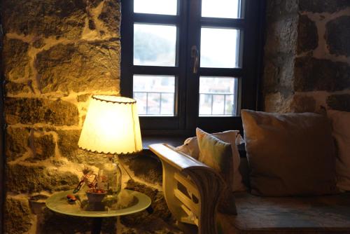 a lamp on a table in a room with a window at The fig tree house in Samothráki