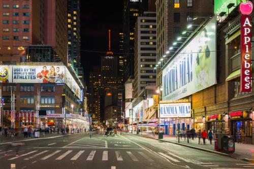 una calle de ciudad vacía por la noche con edificios en Holiday Inn Express - Times Square, an IHG Hotel, en Nueva York