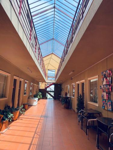 an empty hallway with tables and chairs and a glass ceiling at City East Motel in Melbourne