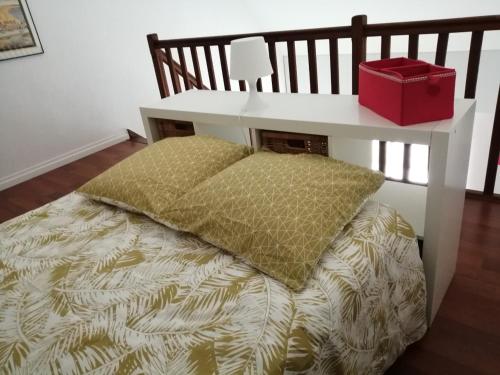 - un lit avec un oreiller et une boîte rouge dans l'établissement Le Soleil et la Mer, à Pornichet