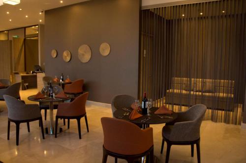a restaurant with tables and chairs and a bar at Holiday Inn Cúcuta by IHG in Cúcuta