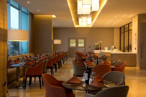 a restaurant with tables and chairs and a bar at Holiday Inn Cúcuta by IHG in Cúcuta