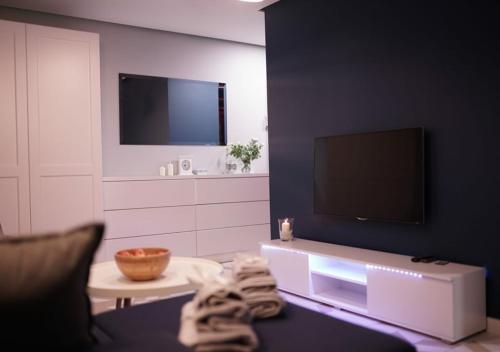 a living room with a tv and a couch at Apartament Augustów SWAN in Augustów