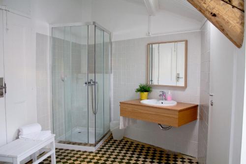 a bathroom with a sink and a glass shower at WW Hostel & Suites in Coimbra
