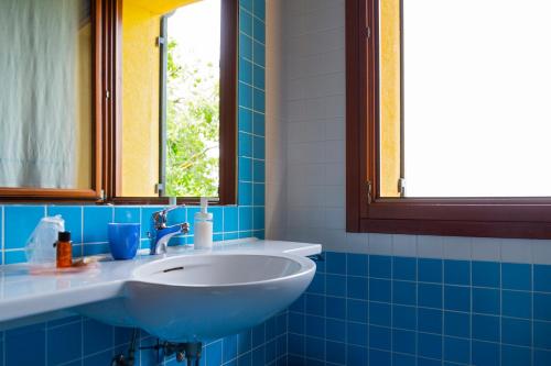 a blue tiled bathroom with a sink and a window at Sant'Andrea Agriturismo con cantina Martignago Vignaioli Asolo Prosecco Docg Wines in Maser