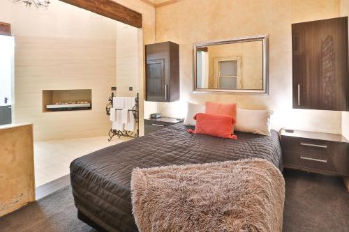 a bedroom with a large bed and a bathroom at Indulge Apartments - Eighth in Mildura