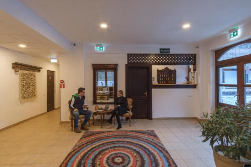 two men sitting at a table in a lobby at Pensiunea Sibiel in Sibiel