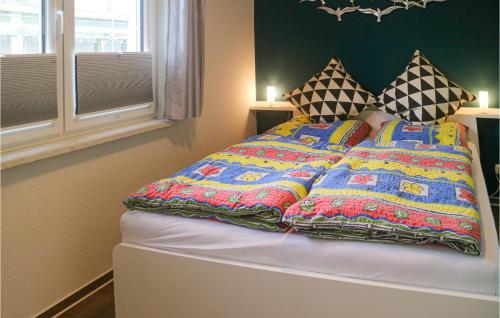 a bed with colorful blankets and pillows on it at Stunning Apartment In Graal-mritz With 1 Bedrooms And Wifi in Graal-Müritz