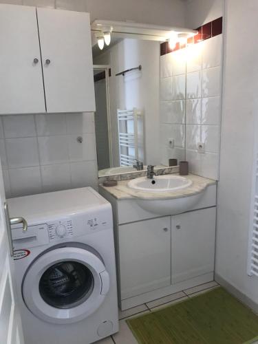 une petite salle de bains avec un lave-linge et un lavabo dans l'établissement Saint-Pierre-la-Mer - Narbonne Plage Location T3 Climatisée, à Saint Pierre La Mer