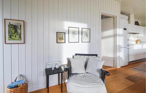 a living room with a chair and a refrigerator at Four-Bedroom Holiday Home In Juelsminde in Juelsminde