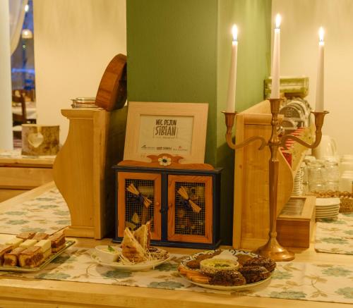 a table with food and candles on top of it at Pensiunea Sibiel in Sibiel