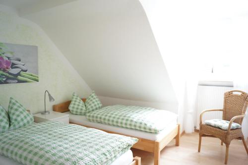 a bedroom with two beds and a chair at Ferienwohnung Kunkel in Kreuzau