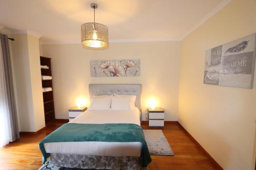 a bedroom with a large bed and two lamps at Funchal Apartment, with pool in Funchal