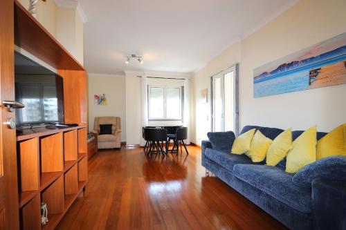 a living room with a blue couch with yellow pillows at Funchal Apartment, with pool in Funchal