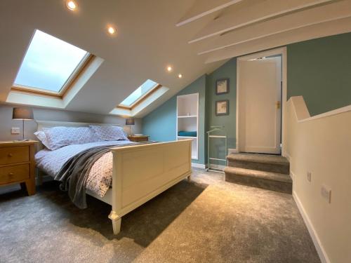 a attic bedroom with a bed and skylights at The Annexe, Tregoose House in Newquay