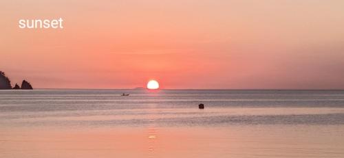 a sunset over the ocean with a person in the water at Isla Water Sports and Resorts in Mabini
