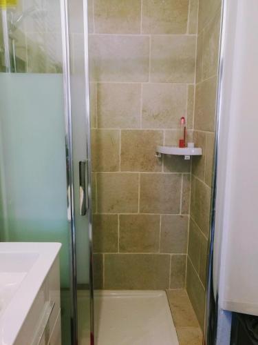 une salle de bain avec une douche avec une porte vitrée dans l'établissement Le Bâbord - petit studio ambiance bateau à 30 m de la mer, à Palavas-les-Flots