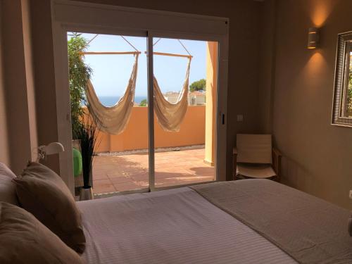 米哈斯NEW: LUXURIOUS PENTHOUSE WITH JACUZZI & SEA VIEW的一间卧室，里面有一张床和一扇推拉玻璃门