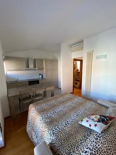 a bedroom with a leopard print bed and a kitchen at Suite Mavino Appartamenti in Sirmione