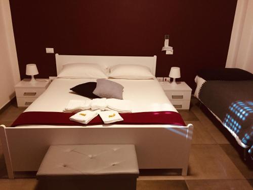 a bedroom with a large white bed with two tables at Pit Lane AFFITTACAMERE in Offida