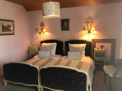 a bedroom with a black bed with two pillows at La Maison de juliette in Saint-Hippolyte